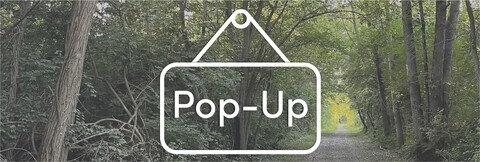 Transparent sign icon that says Pop-Up overlaid on photo of wooded trail