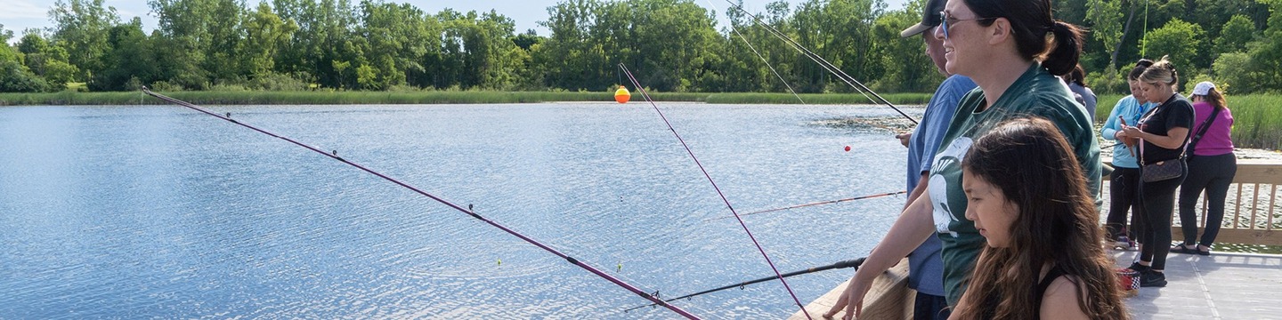 A mother and daughter fishing off of the new fishing pier at Pontiac Oaks