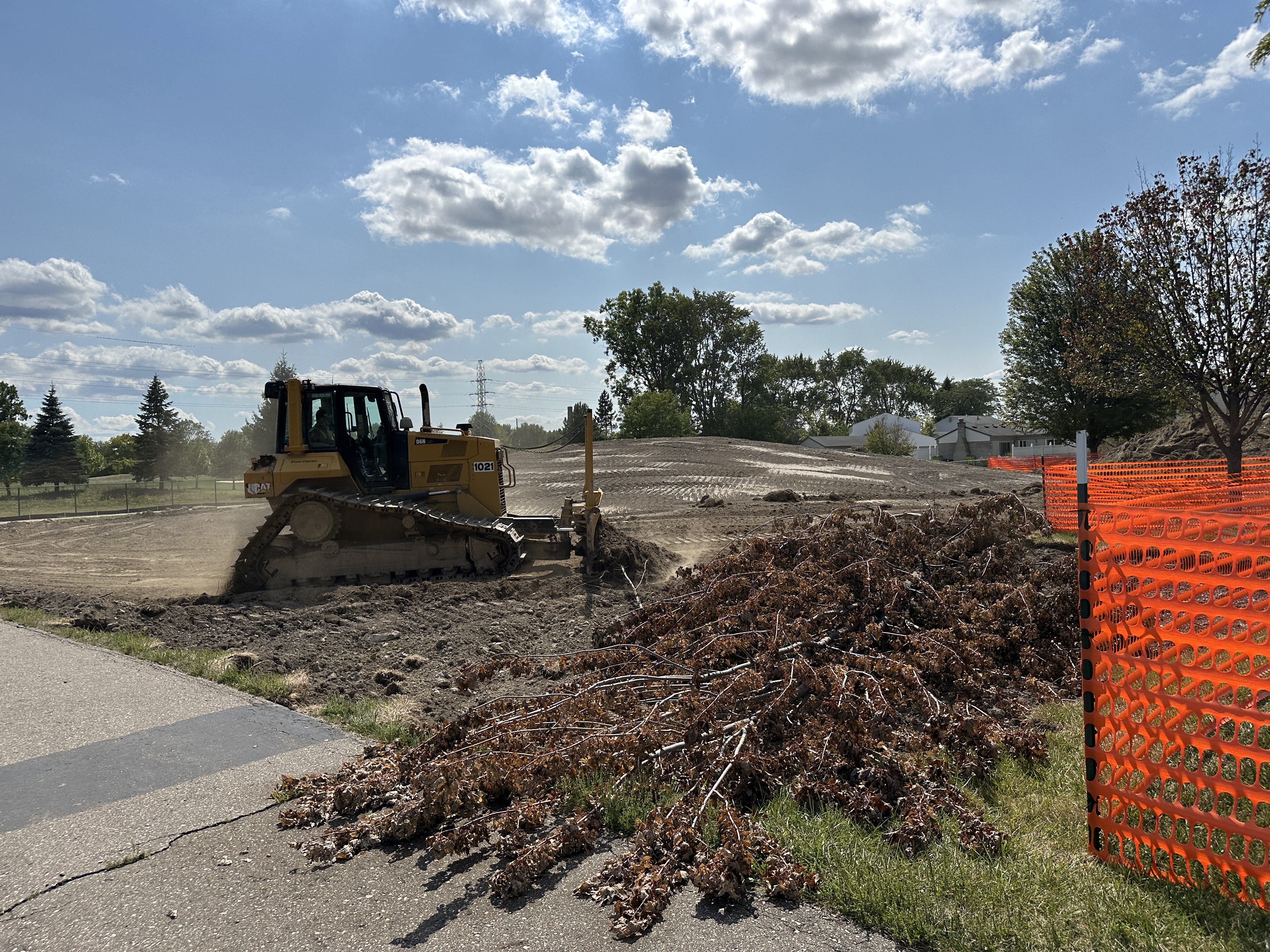 Construction equipment pushing dirt at the park on a bright sunny day